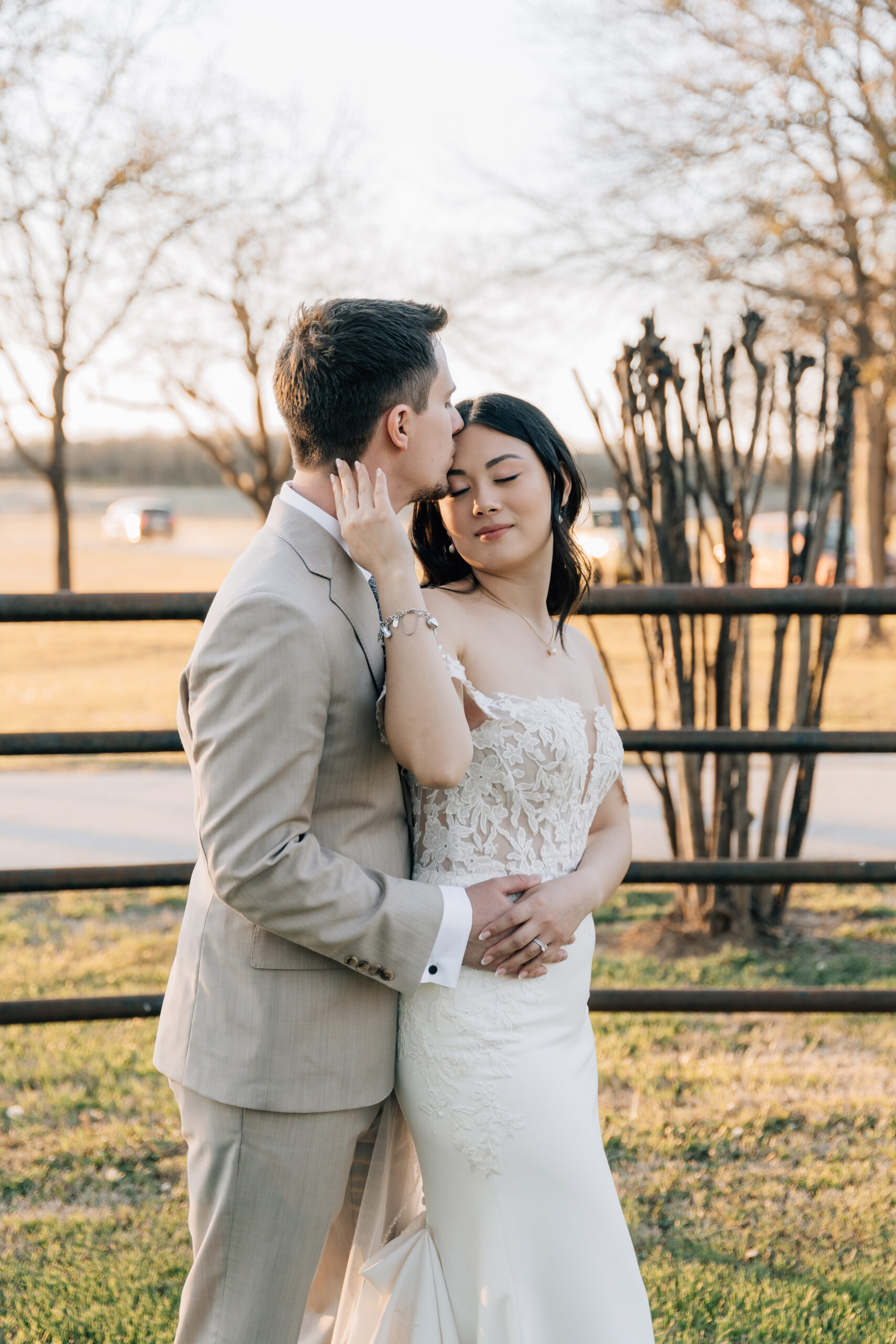Groom kisisng bride in her forehead during golden hour at classic oaks in Mansfield TX