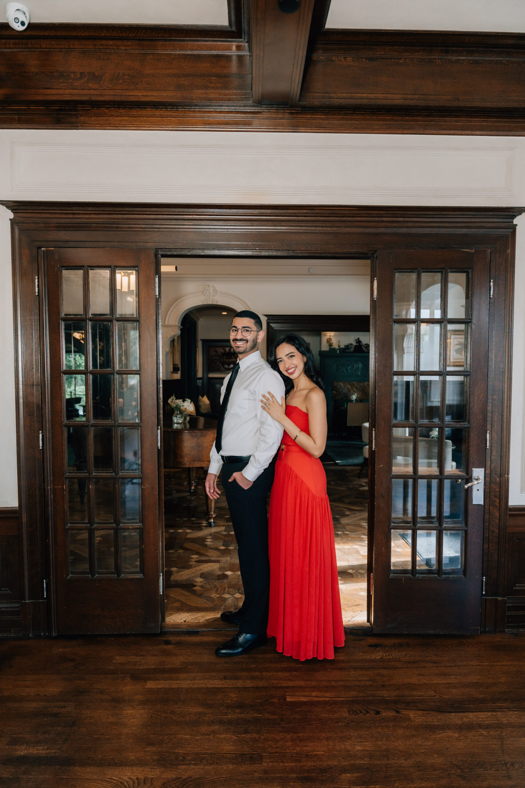Engaged couple standing back-to-back in elegant interior doorway at Colombe d’Or – classic engagement portrait by Houston wedding photographer