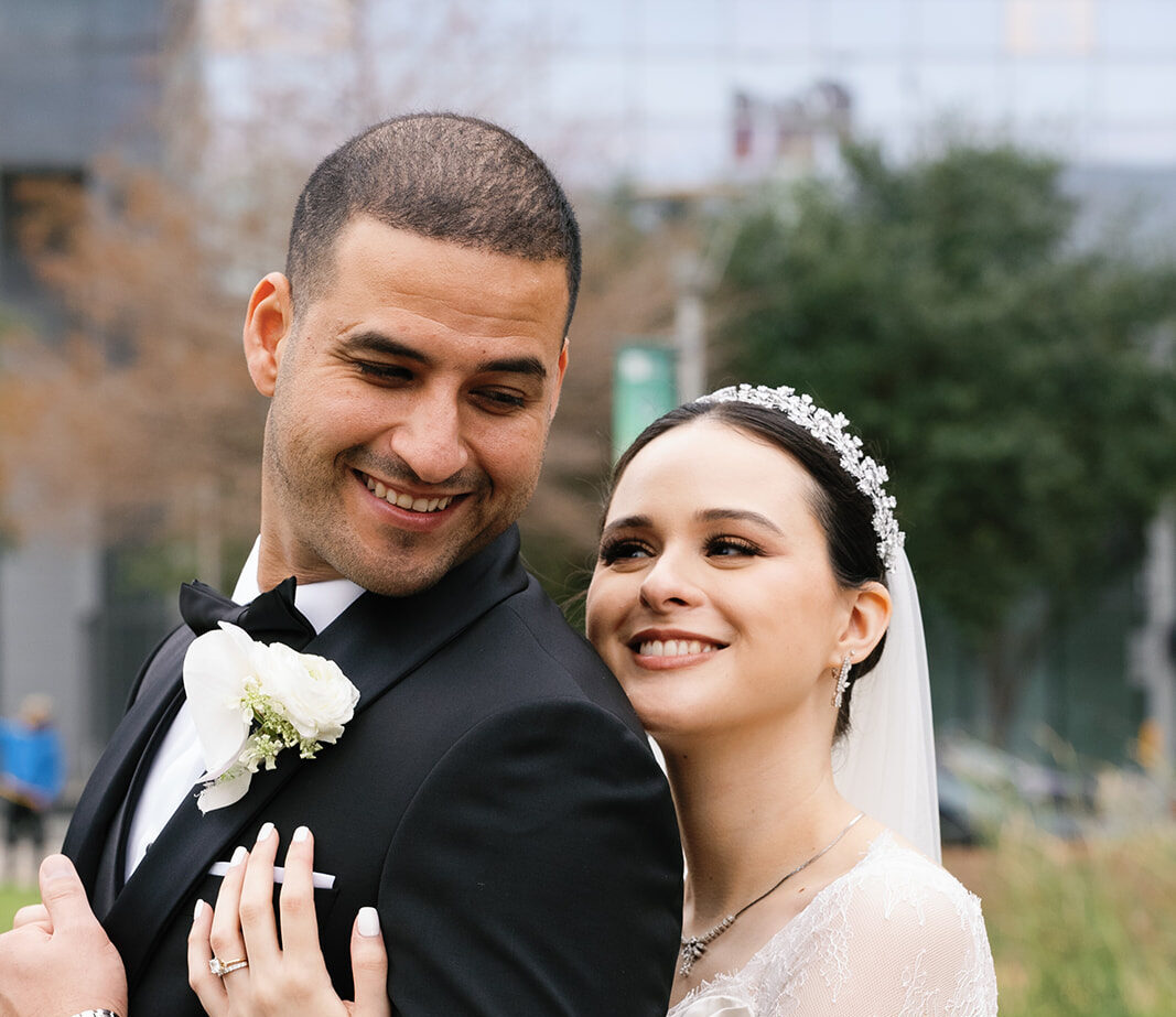 Bride hugging groom from behind in Houston