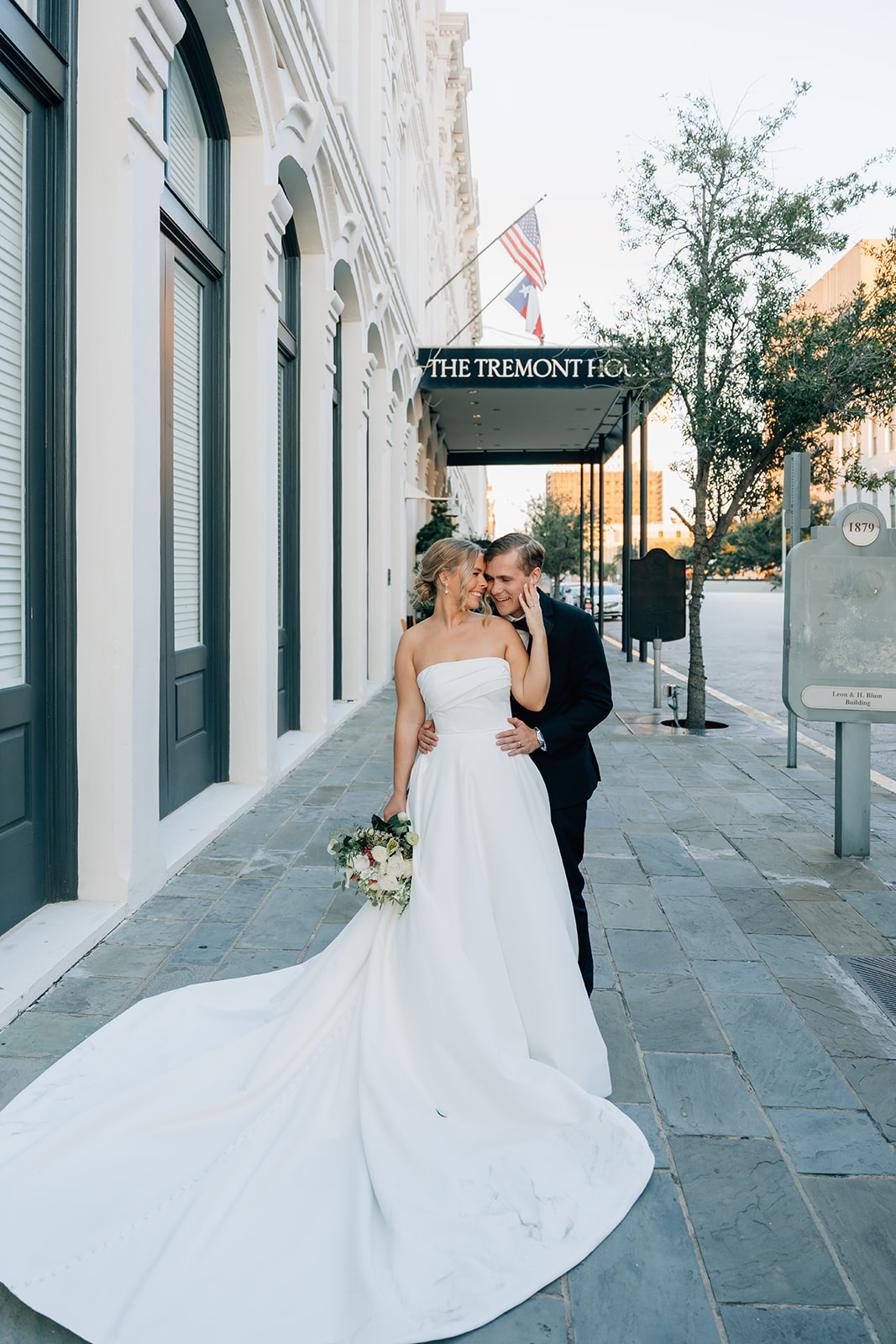 Bride and groom embracing outside The Tremont House in Galveston photographed by Houston wedding photographer Katia G Photography